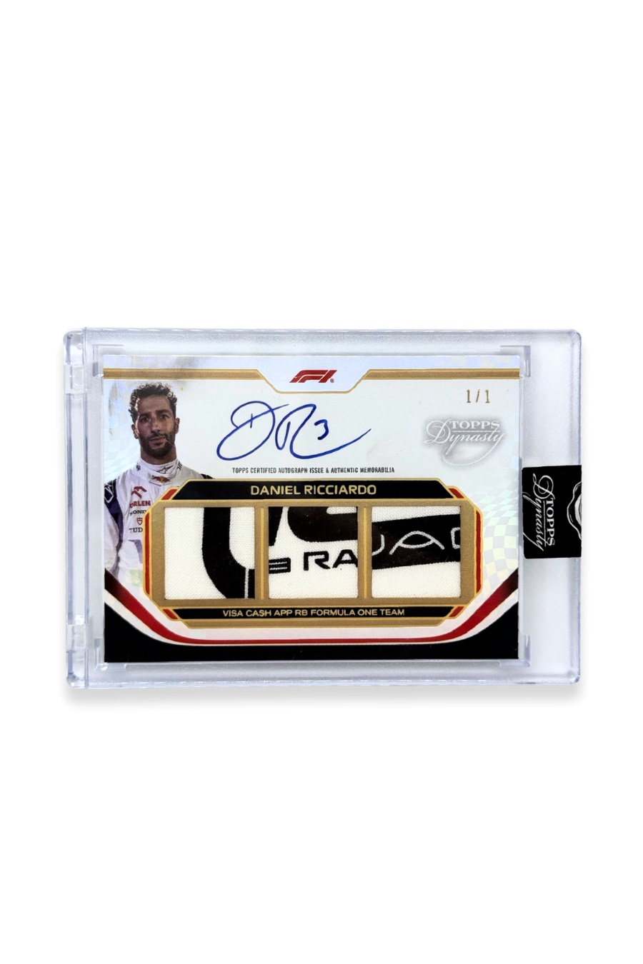 Front of 2024 Topps Dynasty Daniel Ricciardo triple patch autograph card, serial numbered 1 of 1, showing three memorabilia patch windows with partial team branding lettering.