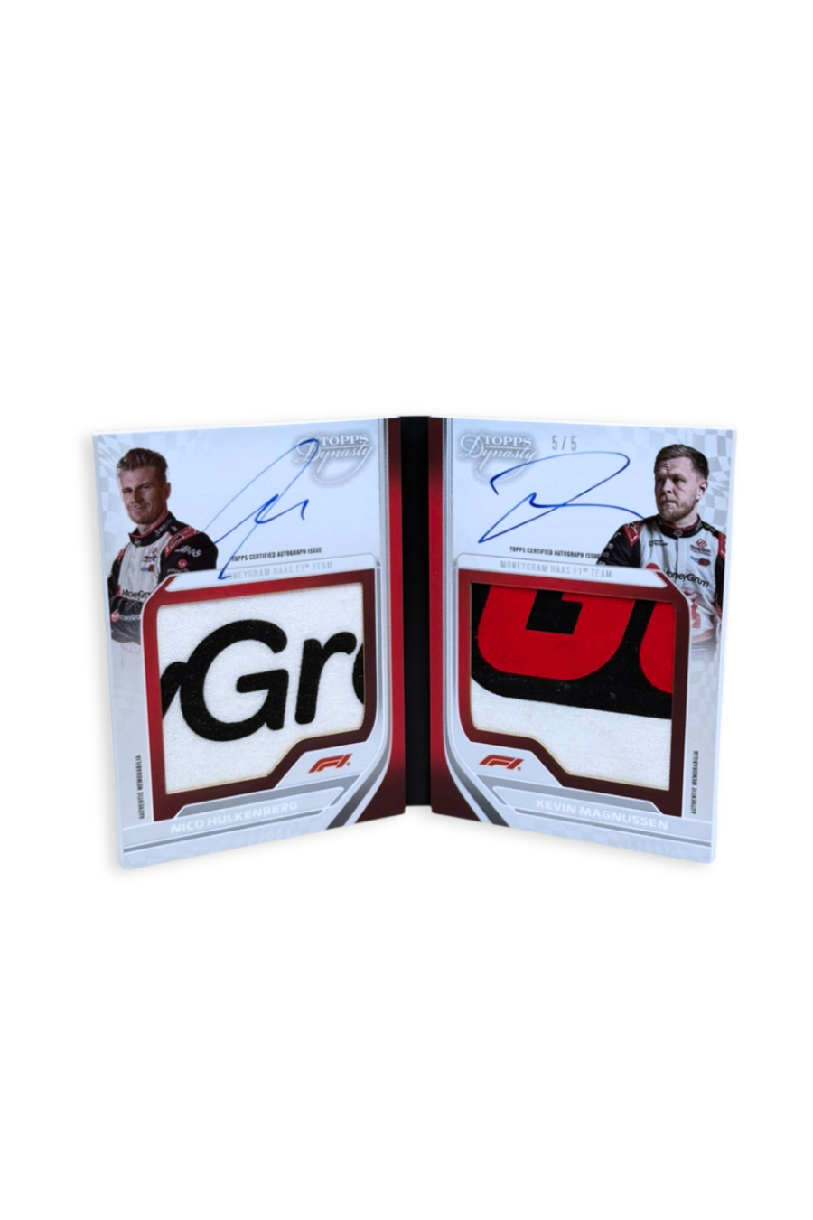 Front of 2024 Topps Dynasty Dual Patch Auto Booklet card featuring Nico Hülkenberg and Kevin Magnussen, serial numbered #5/5 with large patches and autographs