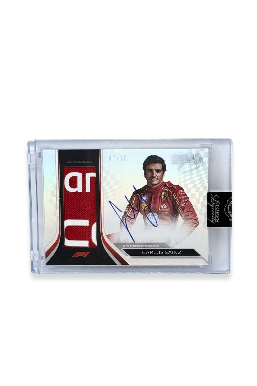 Front of 2024 Topps Dynasty Carlos Sainz patch autograph card, serial numbered 7 of 10, featuring red authentic memorabilia patch with white lettering from Scuderia Ferrari.