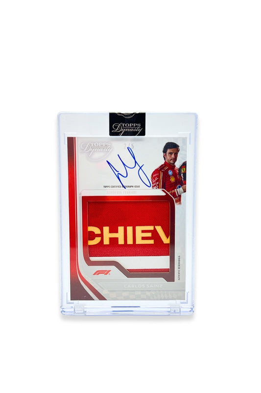 Front of 2024 Topps Dynasty Carlos Sainz jumbo patch autograph card, serial numbered 2 of 5, featuring a red patch with yellow “CHIEV” lettering fragment.