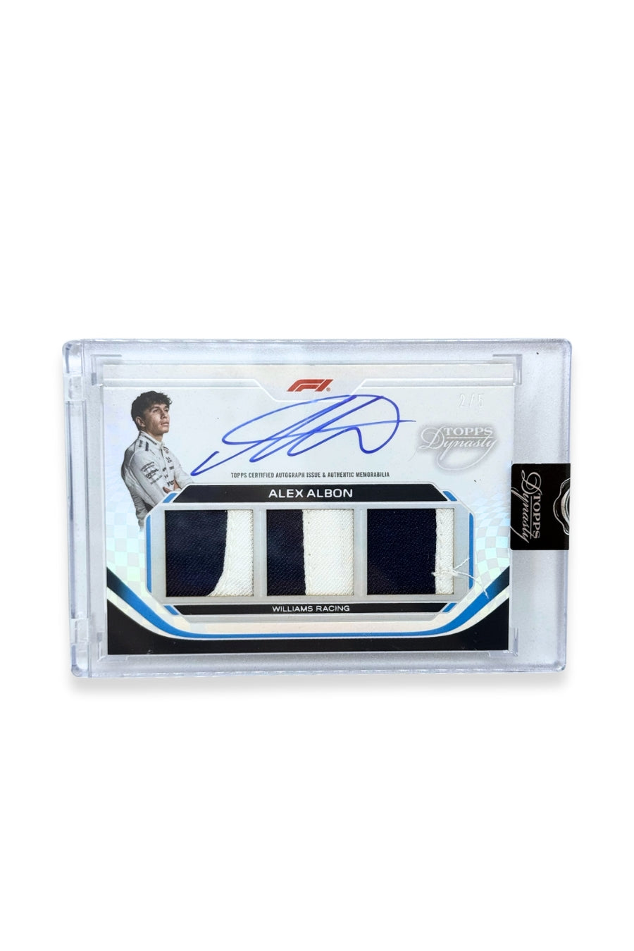 Front of 2024 Topps Dynasty Alex Albon triple patch autograph card, serial numbered 2 of 5, featuring navy blue and white authentic memorabilia patches from Williams Racing.