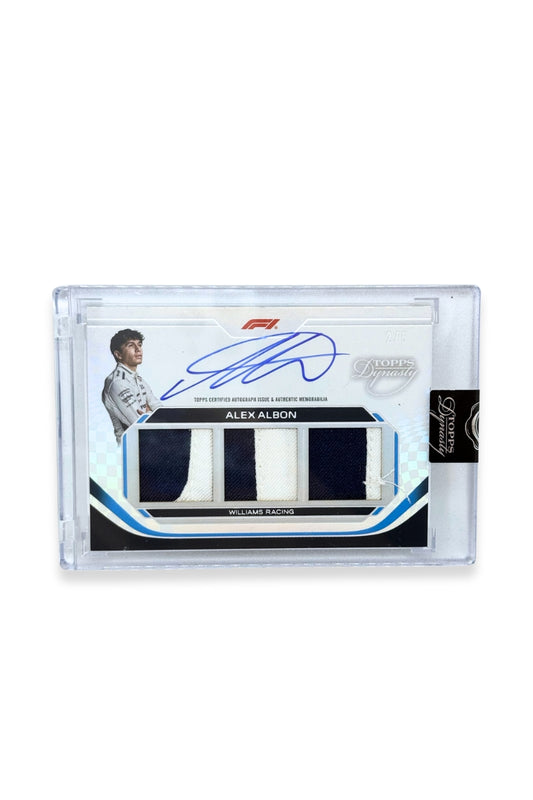 Front of 2024 Topps Dynasty Alex Albon triple patch autograph card, serial numbered 2 of 5, featuring navy blue and white authentic memorabilia patches from Williams Racing.