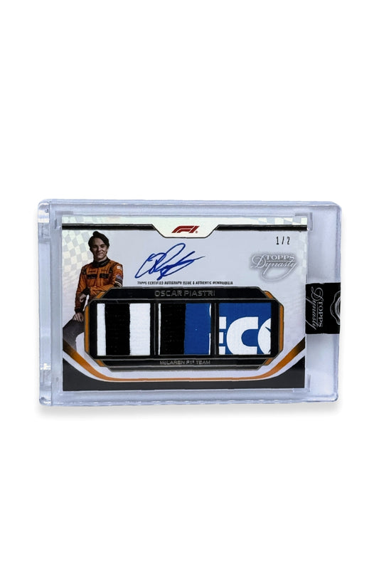 2024 Topps Dynasty Oscar Piastri Triple Patch Auto #1/2 featuring black, white, and blue patches and an on-card autograph.
