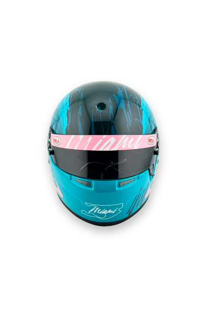 Front view of 2024 Miami GP Paddock Club Bell mini helmet, featuring visor with pink  and white Miami lettering.